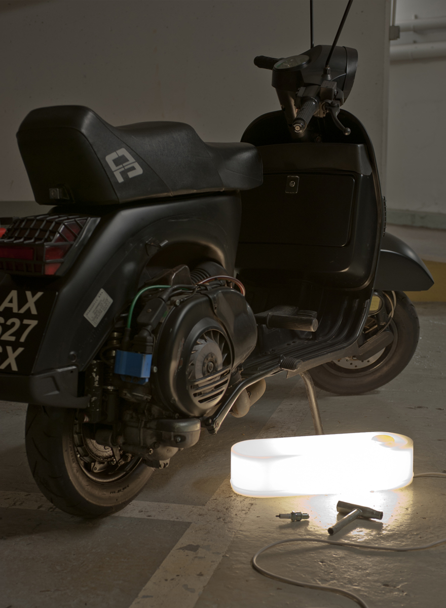 Hit Box design Frédéric Sofia lampe allumée en plastique blanc posé au sol dans un garage